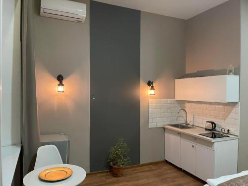 una pequeña cocina con fregadero y mesa en Aparthotel Old Avenue, en Tiflis