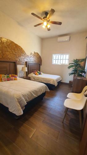 a bedroom with two beds and a ceiling fan at La casita de Carmen con terraza in Cuatrociénegas de Carranza