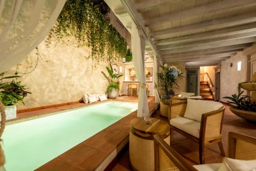 a swimming pool in a room with a table and chairs at Moet Cartagena Hotel Boutique in Cartagena de Indias