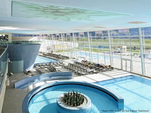 a large building with a swimming pool in a building at Holiday Home Haus Weickl by Interhome in Kaprun
