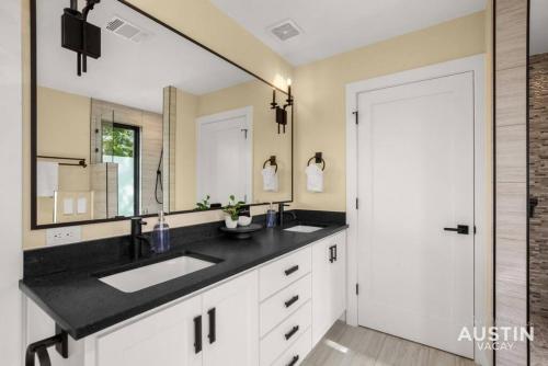 a bathroom with a sink and a large mirror at Stunning Two Living Rooms and 3-Room Primary Suite in Austin