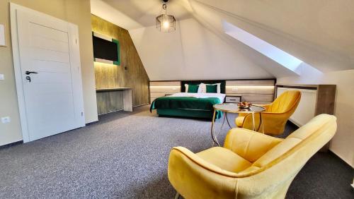 Habitación de hotel con cama, mesa y sillas en Loft by Lumiere Sibiu, en Sibiu