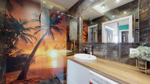 a bathroom with a palm tree mural on the wall at Apartament 44 Aquapark Reda in Reda