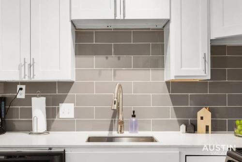 a kitchen with a sink and white cabinets at Remodeled Apt w Gated Community and In-Unit Laundry in Austin