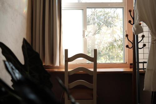 kaabna spa في فيلاهيرموسا: نافذة في غرفة بها كرسي ومصنع
