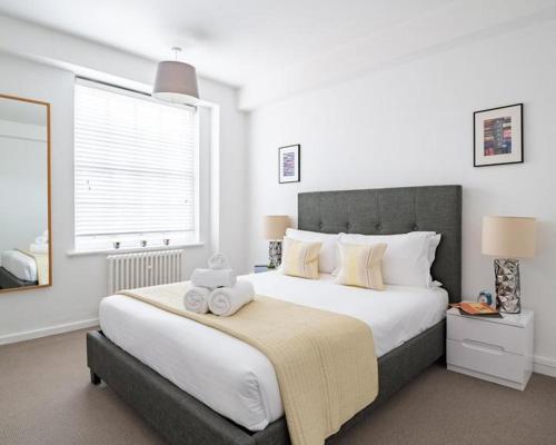 um quarto com uma cama grande com duas toalhas em Buckingham Palace Observatory em Londres