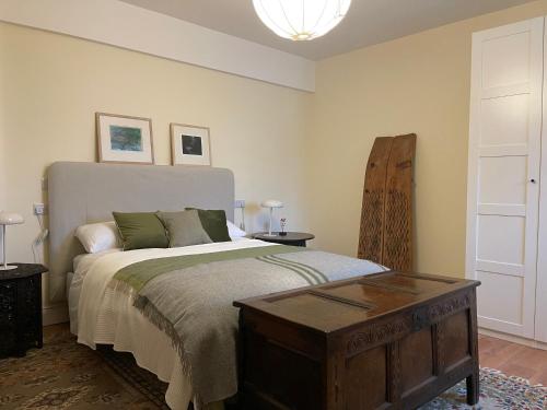1 dormitorio con 1 cama grande y mesa de madera en Riverfront Apartments at The Blue Goat Ramelton, en Ramelton
