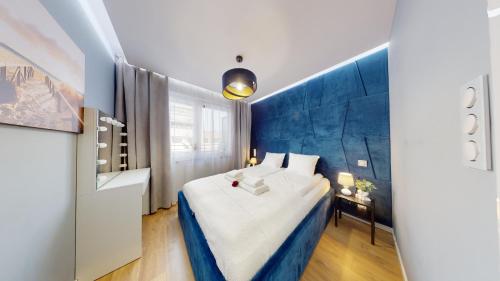 Habitación de hotel con cama y pared azul en Apartament 44 Aquapark Reda, en Reda