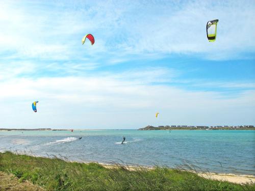 a group of people flying kites in the water at Holiday Home Ty Ruz by Interhome in Plouescat
