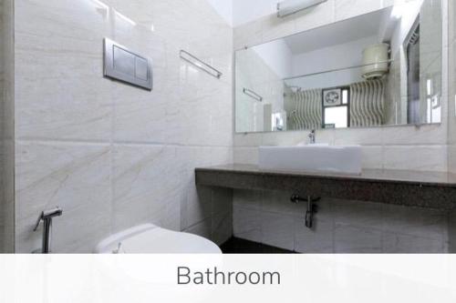 a bathroom with a sink and a toilet and a mirror at Luxury 9BHK Villa with Private Pool Near Candolim in Marmagao