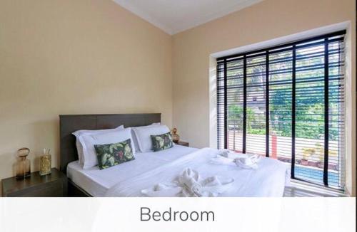 a bedroom with a large bed with a large window at Luxury 9BHK Villa with Private Pool Near Candolim in Marmagao