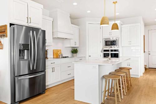 a kitchen with white cabinets and a stainless steel refrigerator at The Pearl at Desert Shores townhouse in St. George