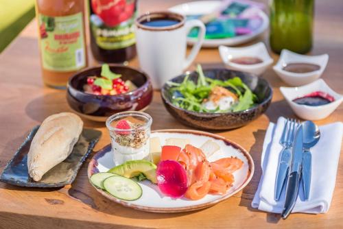 a wooden table with plates of food and bowls of food at Hôtel La Garenne in Saverne