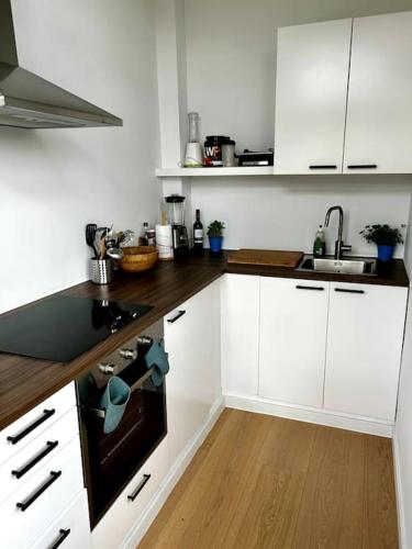 a kitchen with white cabinets and a stove top oven at Apartment near central station in Antwerp