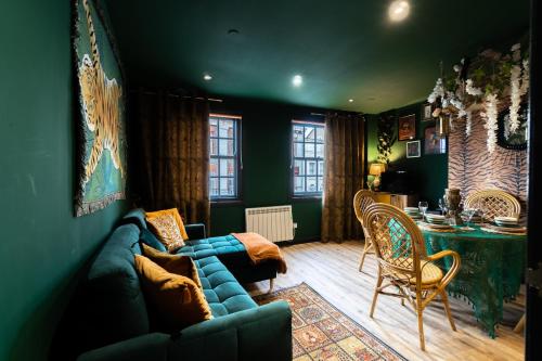 uma sala de estar com um sofá azul e uma mesa em The Emerald Suite by Margate Suites em Margate
