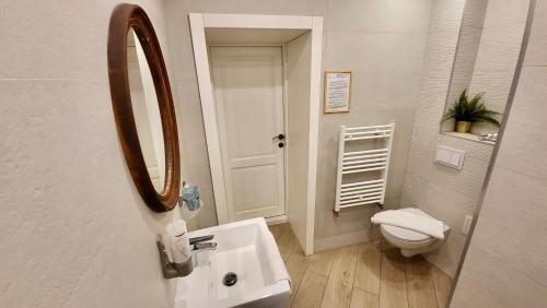 a bathroom with a sink and a toilet and a mirror at Lumiere House Sibiu in Sibiu