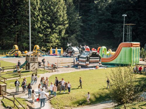 a group of people walking around a playground at Chalet Chalet 969 by Interhome in Moleson