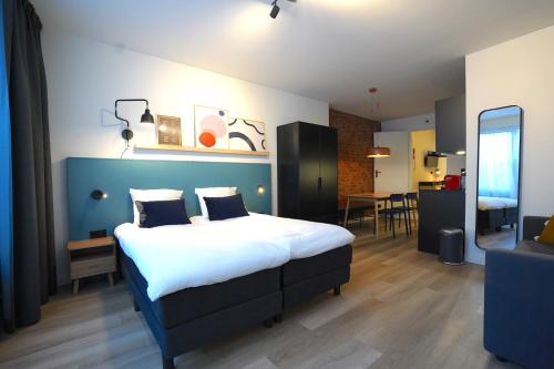 a bedroom with a large bed and a living room at Zest Hotel Daalhemerweg in Valkenburg