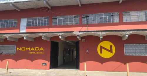 a red building with a namdania sign on it at Nomada Hostel Oaxaca - Vive nómada! in Oaxaca City