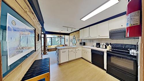 a large kitchen with white cabinets and black appliances at Two Bedroom Units at 1849 Condos with 3 Hot Tubs & Slopeside in Mammoth Lakes
