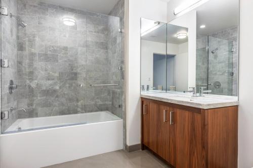 a bathroom with a tub and a sink and a mirror at Downtown 1BR w Gym Pool nr Disney Concert Hall LAX-372 in Los Angeles