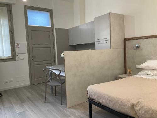 a bedroom with a bed and a table and a kitchen at BOITO36 in Campi Bisenzio