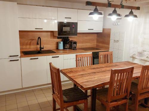 a kitchen with a wooden table and chairs and a sink at Holiday Home Holiday Hill 54 by Interhome in Cerny Dul