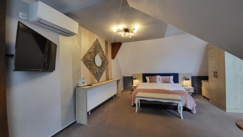 a bedroom with a bed and a flat screen tv at Lumiere House Sibiu in Sibiu