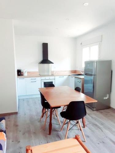 une cuisine avec une table en bois et un réfrigérateur dans l'établissement appartement 45m2 parking gratuit en plein centre ville, à Valras-Plage