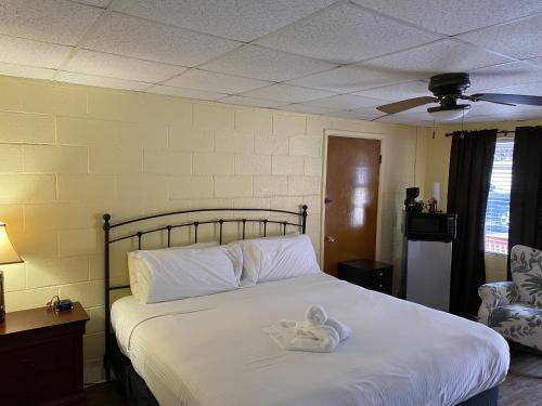a bedroom with a bed with a stuffed animal on it at JI10, a Queen Guest Room at the Joplin Inn, at the entrance to Mountain Harbor Resort Hotel Room in Mount Ida
