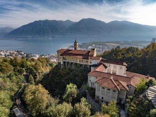 a castle on top of a hill with a body of water at Apartment LocTowers A3-4-2 by Interhome in Locarno