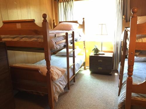1 Schlafzimmer mit 3 Etagenbetten und einem Fenster in der Unterkunft Classic Carnelian Bay Log Cabin in Carnelian Bay