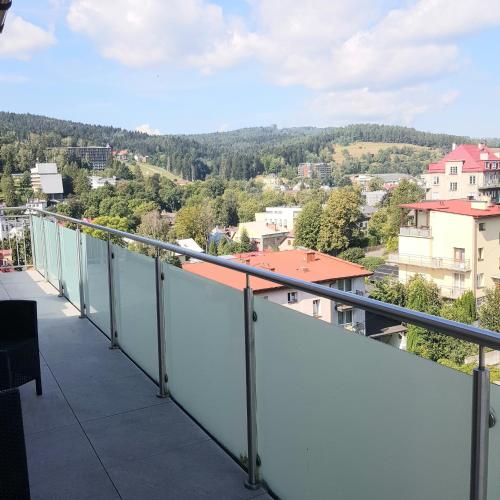 a balcony with a view of a city at Apartamenty Cicha - Centrum in Krynica Zdrój