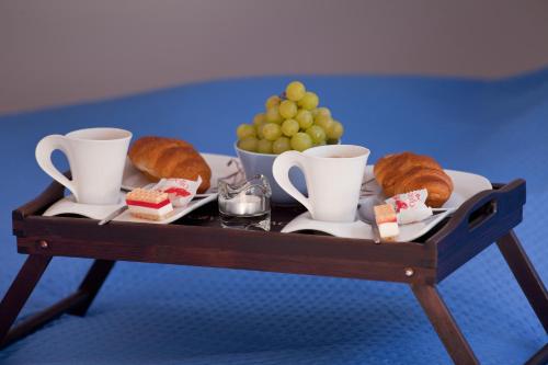 a tray with croissants and cups and a plate of bread at Apartamenty Cicha - Centrum in Krynica Zdrój