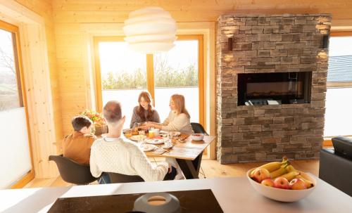 un grupo de personas sentadas alrededor de una mesa en una sala de estar en NETTEN Naturerlebnis Holz-Chalets, en Daun