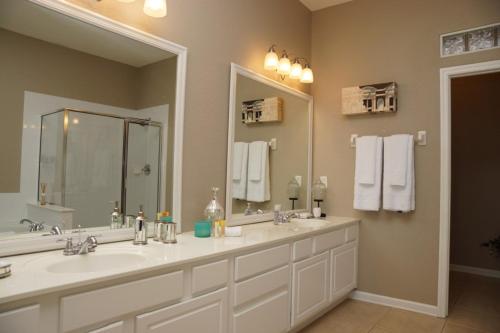 baño con 2 lavabos y espejo grande en Cayview Condo #231543, en Orlando