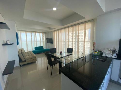 cocina y sala de estar con mesa y sillas en Apartamento frente a la playa, en Cartagena de Indias
