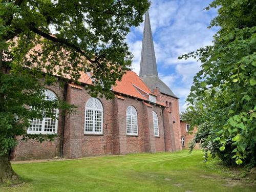 a large brick church with a tall steeple at Apartment Am Ostedeich-2 by Interhome in Oberndorf
