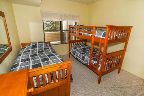 a bedroom with two bunk beds and a window at Seven Springs Stonegate 2 Bedroom Standard Condo, Ski-In Out, Sleeps 8! condo in Champion