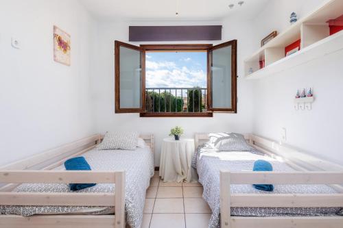 2 Betten in einem Zimmer mit Fenster in der Unterkunft Casa Arturo in Sa Coma