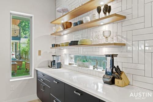 cocina con fregadero, estanterías y ventana en Picture-Perfect Trendy Vibes Minutes From Rainey, en Austin