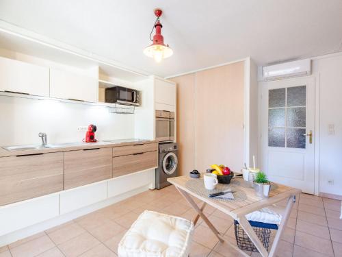 een keuken met witte kasten en een tafel in een kamer bij Apartment Résidence Villa Toscane by Interhome in Saint-Raphaël