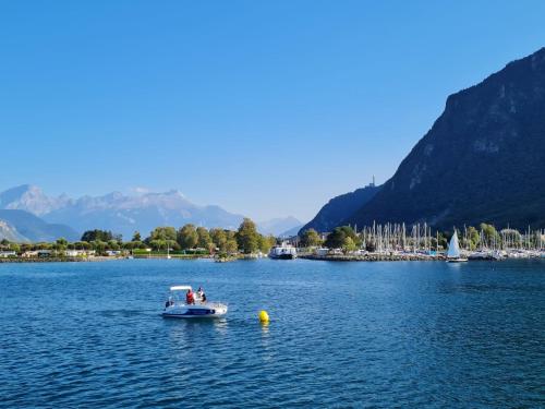 a small boat on a lake with mountains in the background at Apartment Tasman S16-R by Interhome in Bouveret