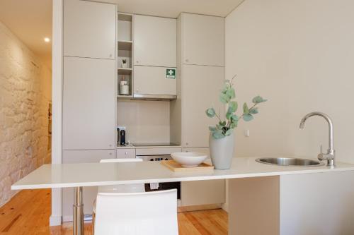 eine Küche mit weißen Schränken und einem Waschbecken in der Unterkunft AgapeStay Porto in Porto