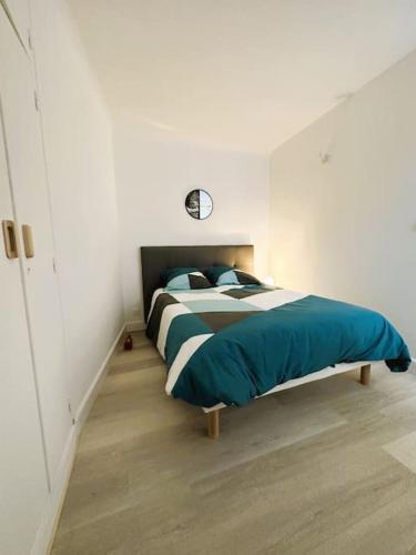 ein Schlafzimmer mit einem Bett mit einer Uhr an der Wand in der Unterkunft Appartement de charme à Sarlat in Sarlat-la-Canéda