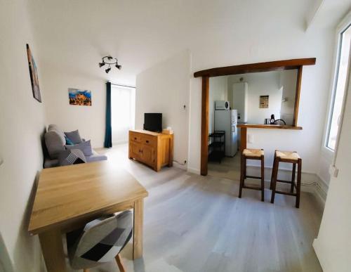 ein Wohnzimmer mit einem Tisch und Stühlen sowie eine Küche in der Unterkunft Appartement de charme à Sarlat in Sarlat-la-Canéda