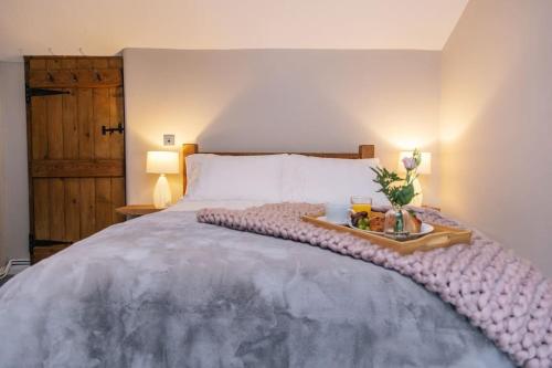 Un dormitorio con una cama con una bandeja de comida. en Ava Lily Cottage, Tideswell, en Tideswell