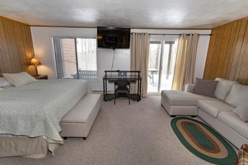 a bedroom with a bed and a couch and a table at Seven Springs - Swiss Mountain 3 Bedroom Standard Condo, Near Golf Course condo in Champion