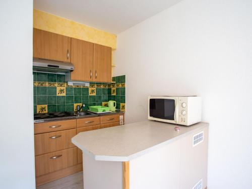 une cuisine avec un four micro-ondes blanc au-dessus d'un comptoir dans l'établissement Apartment Côte d'Azur-16 by Interhome, à Bormes-les-Mimosas