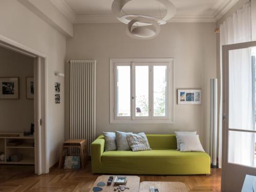 een groene bank in een woonkamer met een raam bij 90m2 lovely 1-bedroom apartment in Paleo Faliro in Athene